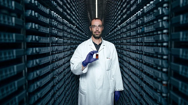 Researcher holding a medicine vial in a compound library at Novartis.