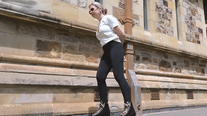 Victoria roller skates past a historic stone building