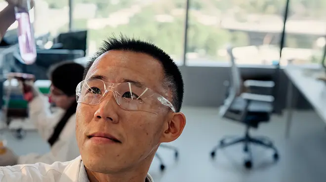 Scientist looking at a test tube with liquid as he holds it in a Novartis lab. Across R&D, our scientists are pushing the boundaries of science to discover and develop breakthrough medicines, moving from molecule to patient with urgency to help people live better, not just longer.