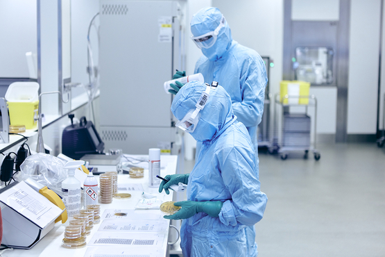 A process operator labels culture plates for environmental monitoring