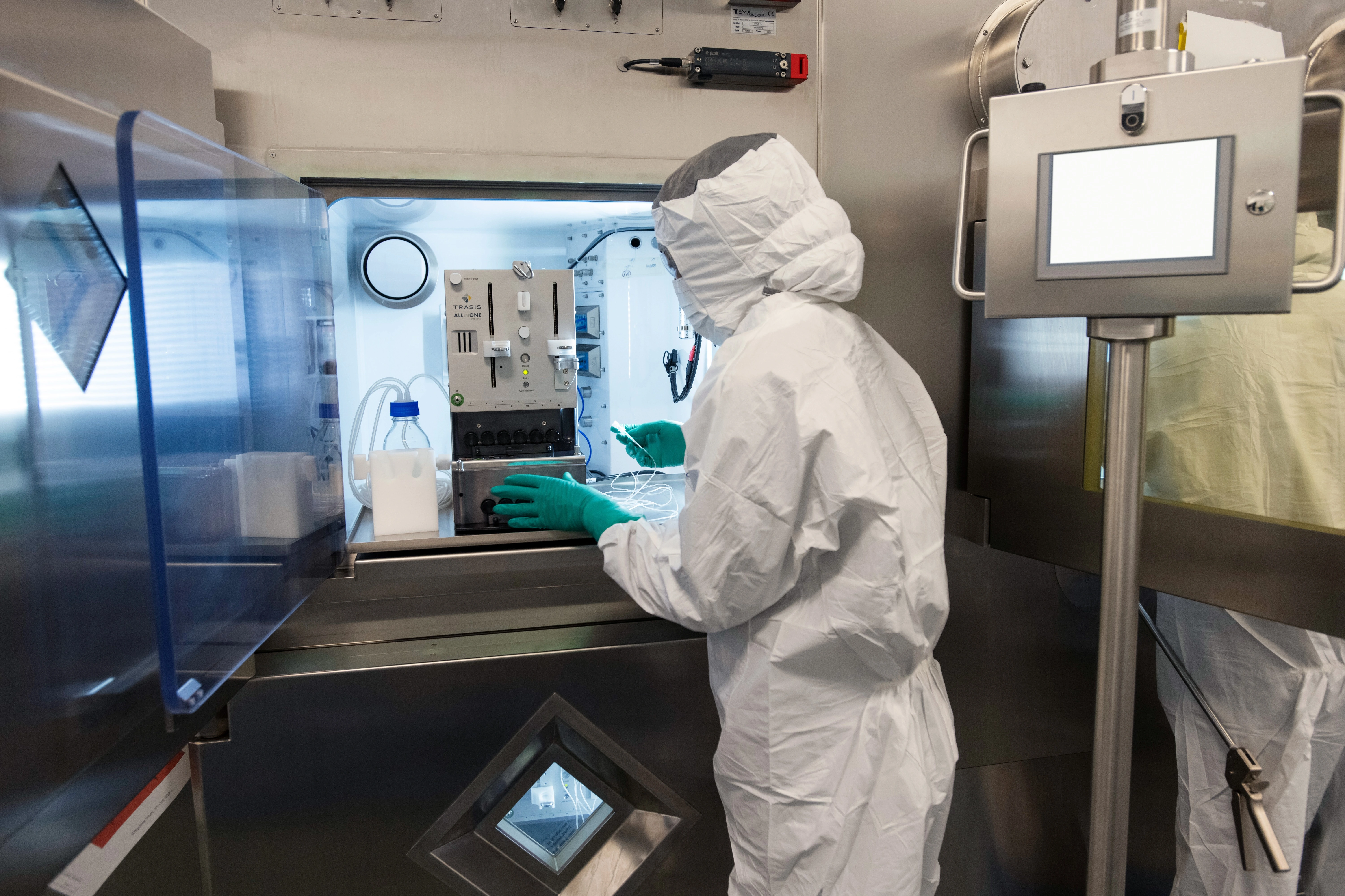 Associate in full personal protective equipment using specialized equipment