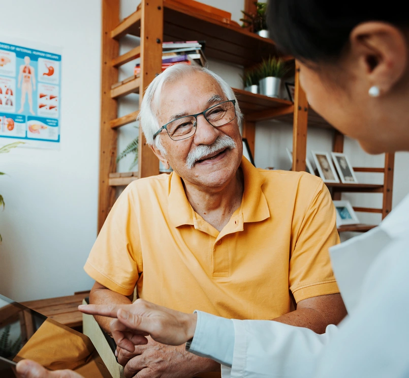 A healthcare professional and senior patient in a conversation using a tablet