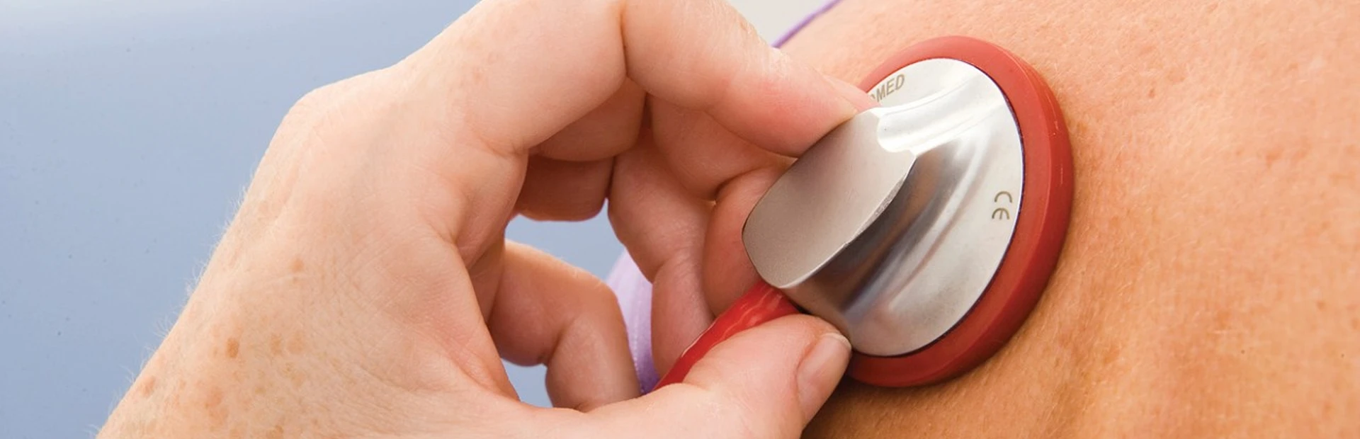 Doctor listening to patient’s lungs with stethoscope