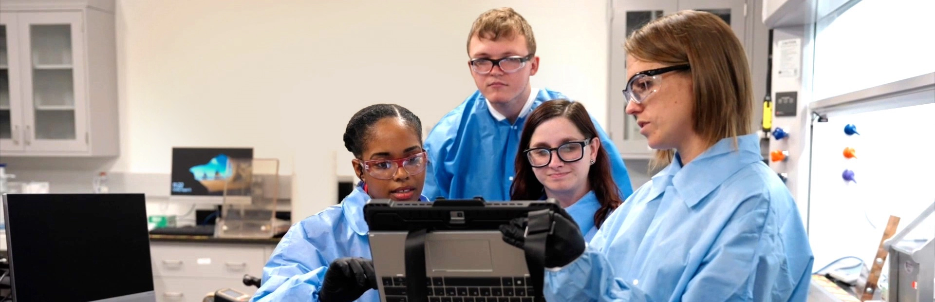 Scientists in a laboratory looking at a tablet