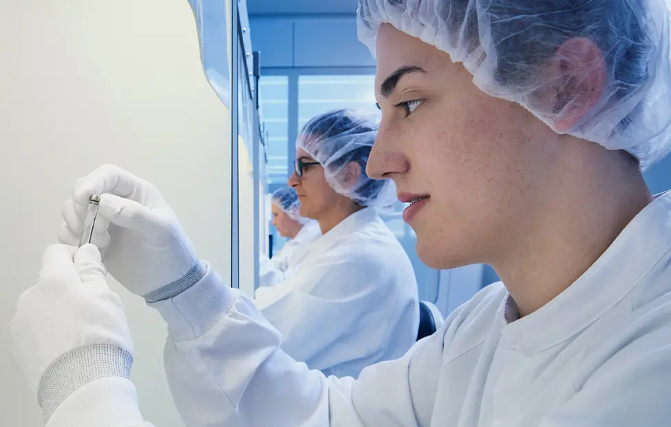 Side-ways view of scientists holding vials in a laboratory
