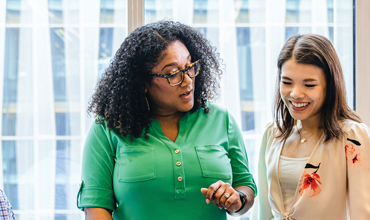 Two women engaged in a conversation at the Novartis office in East Hanover