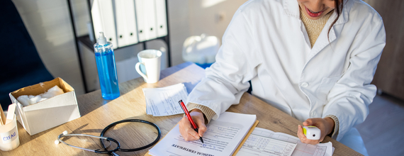 A doctor filling in a clinical trial medical chart