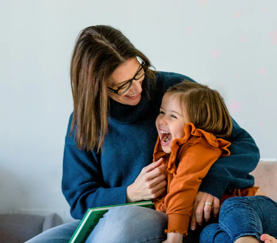A still of a mother and daughter sharing laughter in a children`s room