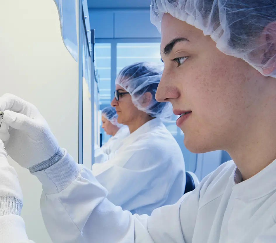 Side-ways view of scientists holding vials in a laboratory