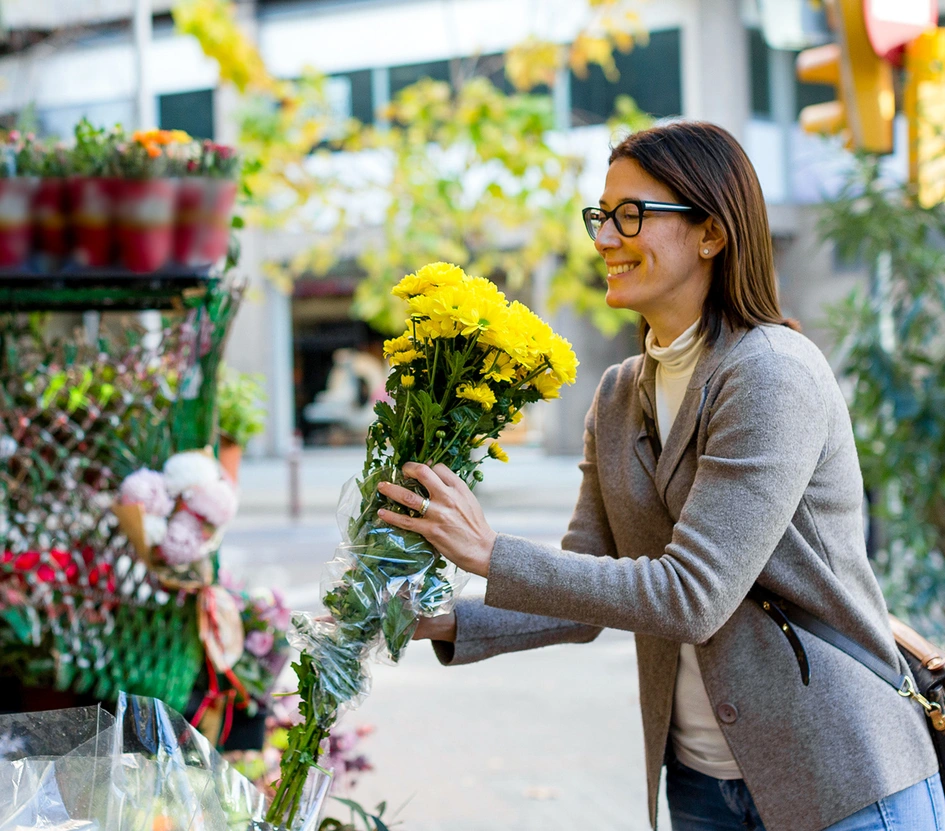 Lady buying yellow flowers in a store