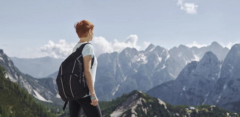 A woman hiking and looking at the mountain range