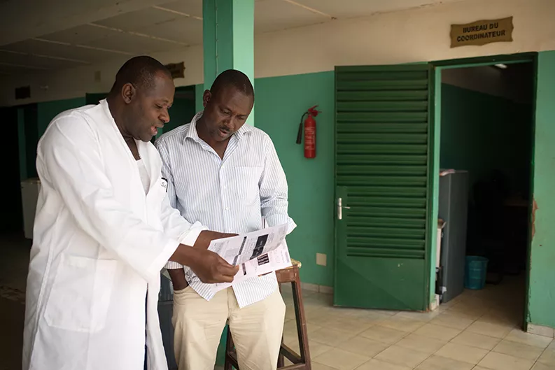 Dr. Bakary Fofana speaks with a colleague at the Bougoula-Hameau health clinic
