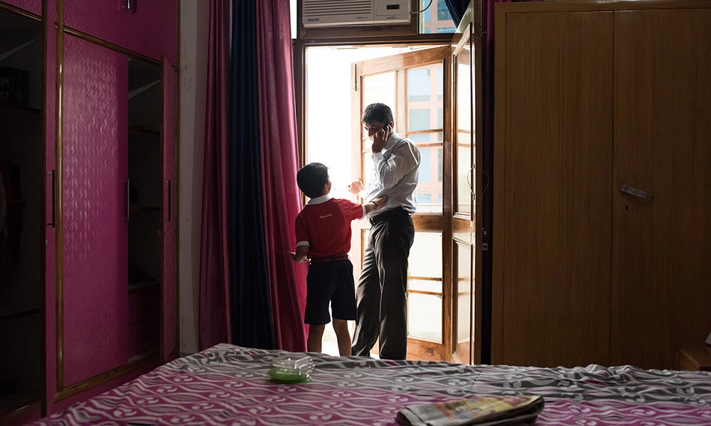 Health educator Chankey Kumar talks to his son before he leaves for work.