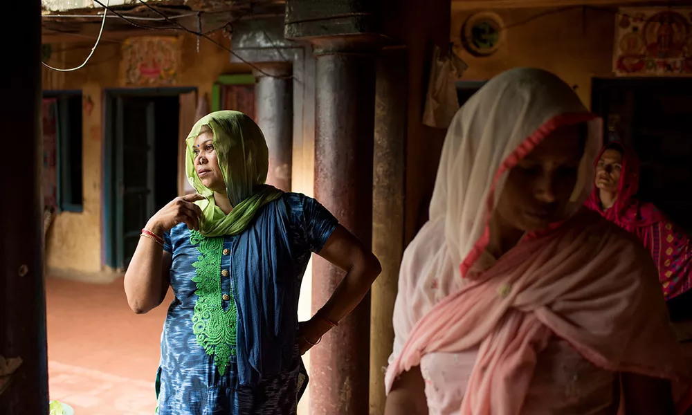 Women in a village near Meerut, India stand in a doorway