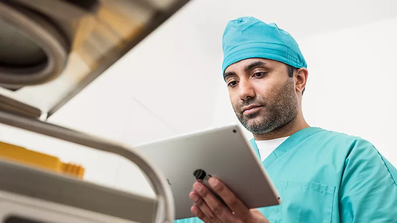 Physician holding a tablet in hospital environment.