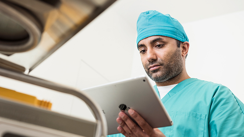 Physician holding a tablet in hospital environment.