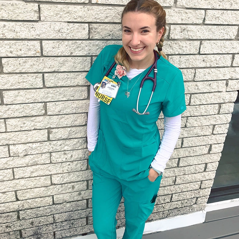Jordan, melanoma survivor and nurse posing in front of building