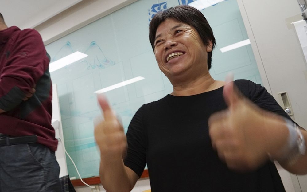 Mrs. Cao gives an enthusiastic thumbs up after a successful operation