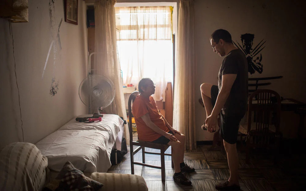 Mr. García goes through an exercise program with his mother. 
