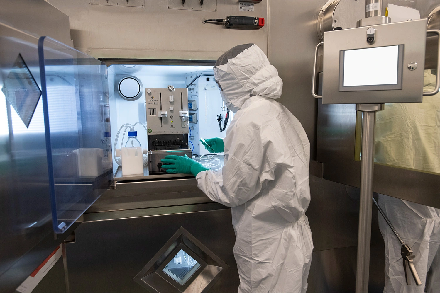 Associate in full personal protective equipment using specialized equipment