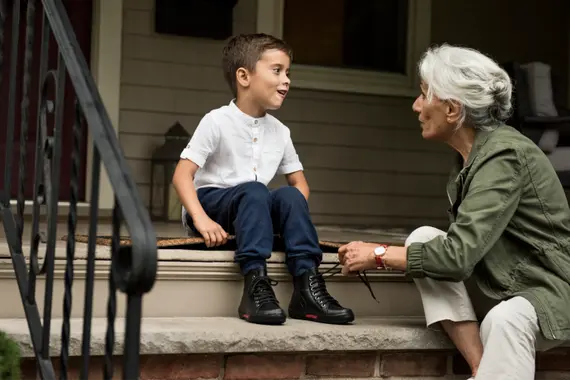 Grandmother tying her grandson's shoe laces
