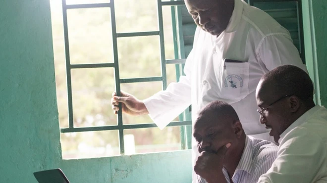 Dr. Bakary Fofana and colleagues look at a computer screen