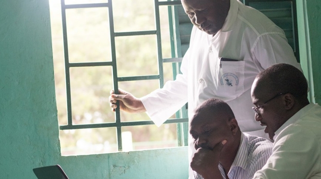 Dr. Bakary Fofana and colleagues look at a computer screen