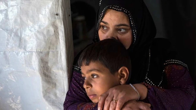 Syrian refugees ponder an uncertain future: Zakiya, one of the daughters of Hamid, with her son Waleed, age 10, in their makeshift home.