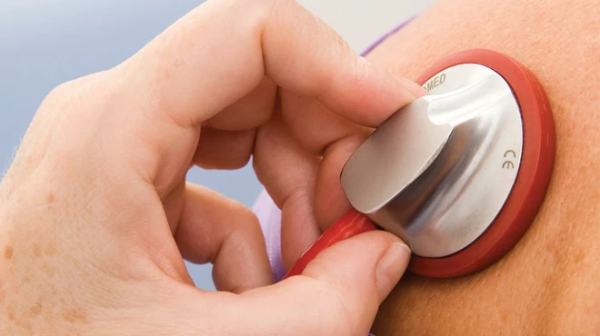 Doctor listening to patient’s lungs with stethoscope