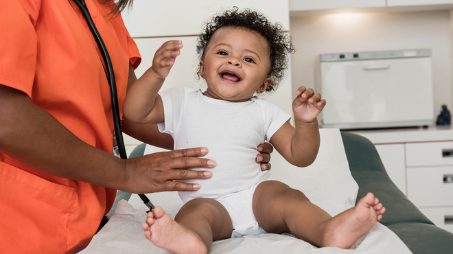 Infant patient being held by a healthcare professional during examination 