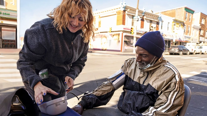 Back cover of the Annual Report 2022. Maggie Perez, a community health worker in Philadelphia, PA, checks the blood pressure of a local resident