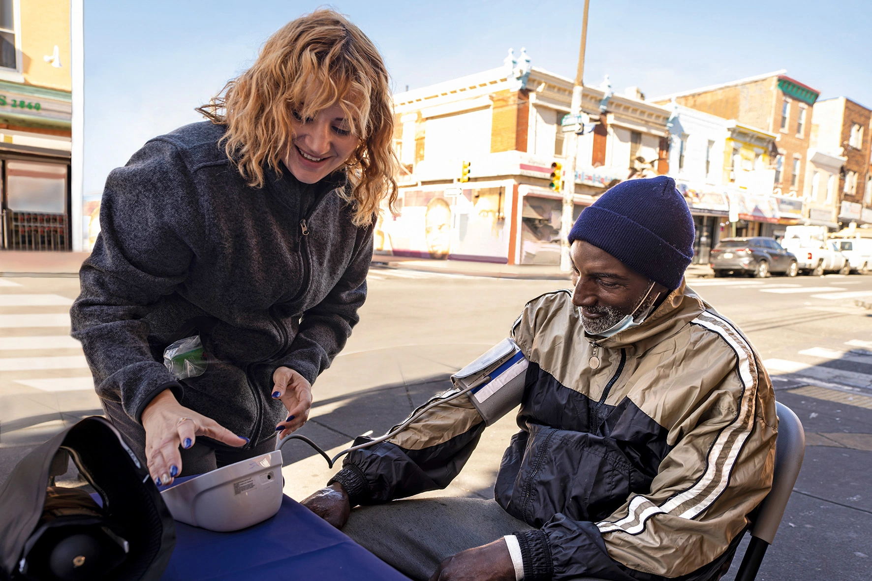 Back cover of the Annual Report 2022. Maggie Perez, a community health worker in Philadelphia, PA, checks the blood pressure of a local resident