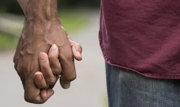 Dvaja ľudia držiaci sa za ruky