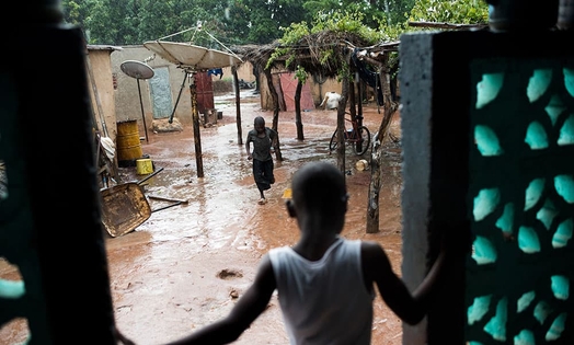 A cild in a house looking at heavy rain