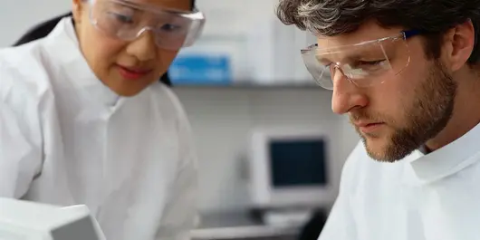 Two scientists looking at a screen