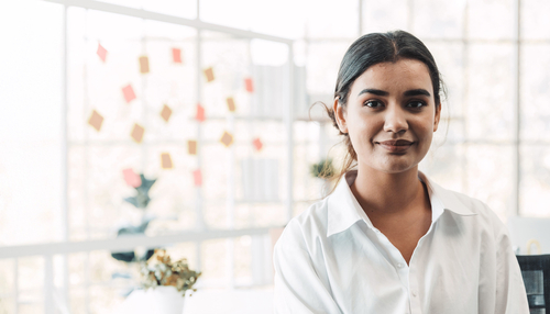 Business person with a whiteboard behind them in a modern office