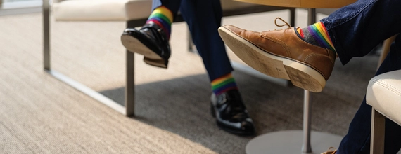 People with rainbow socks sitting on chairs in a waiting room
