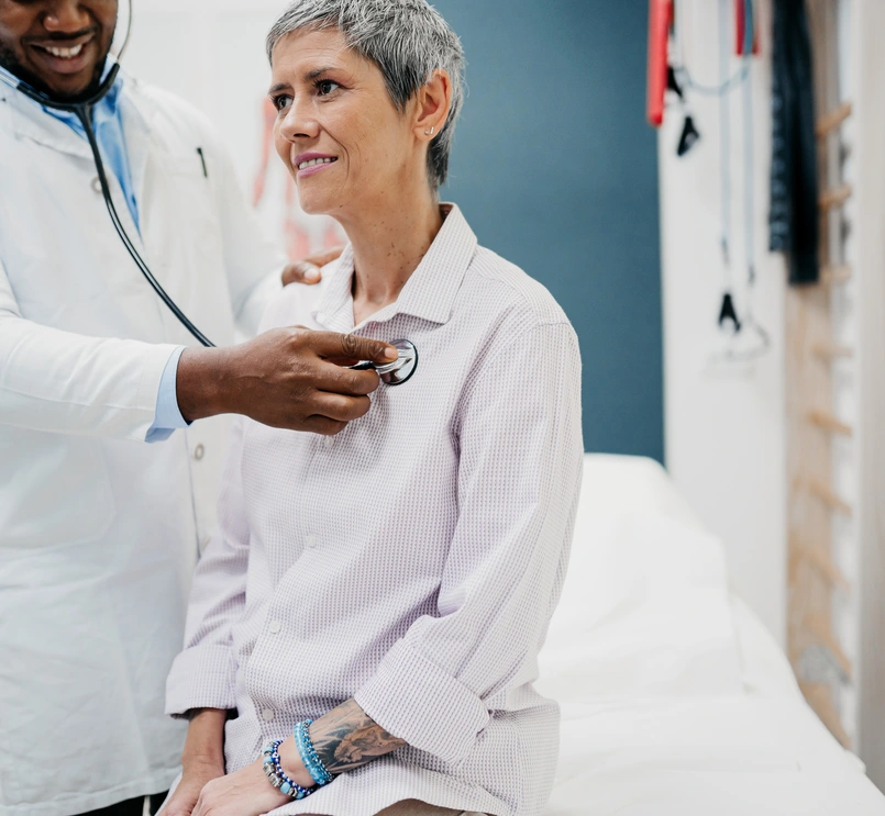 Doctor using stethoscope on patient