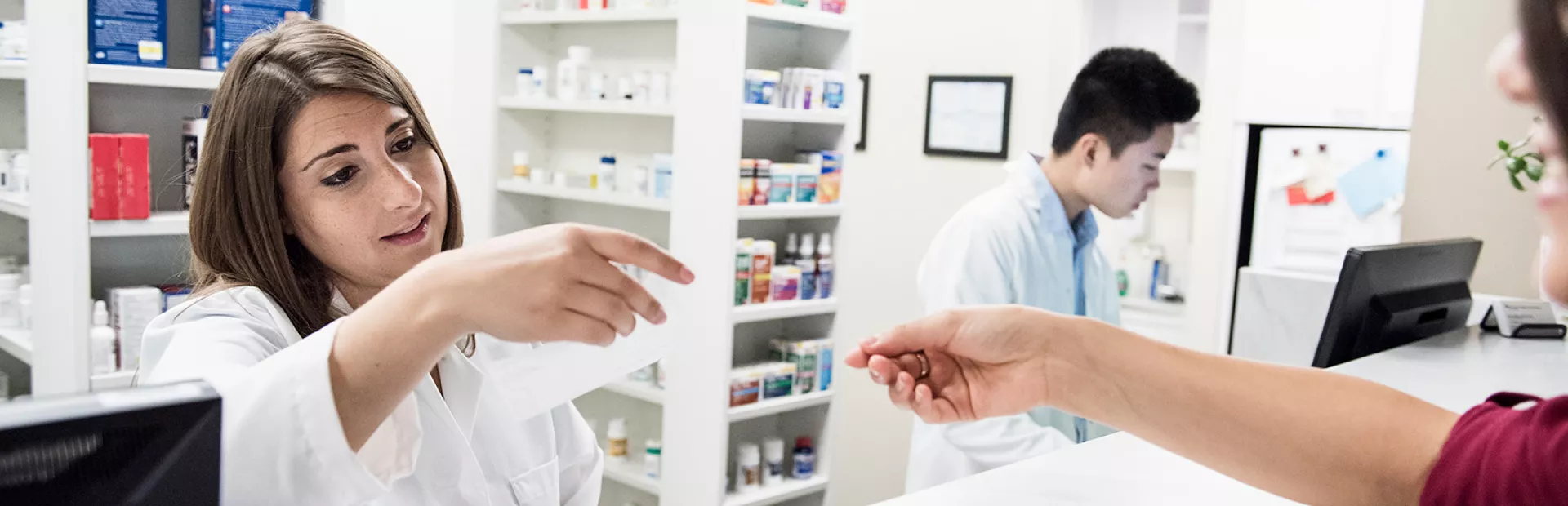 Pharmacist reading customer's prescription