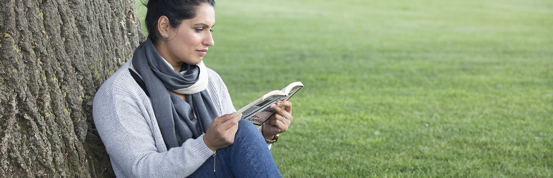 Woman relaxing under a tree reading a book