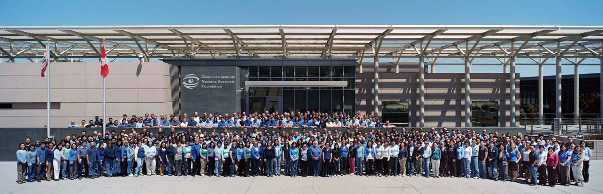 Large group photo of hundreds of Novartis San Diego research associates and scientists gathered in front of the GNF building in 2010