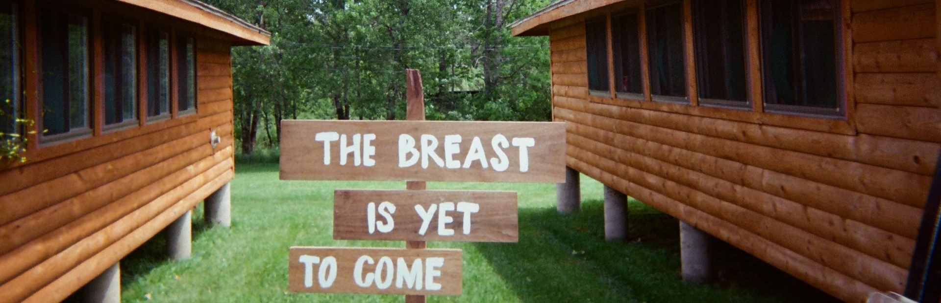 Camp Breastie cabins with a sign reading, "The Breast Is Yet To Come."