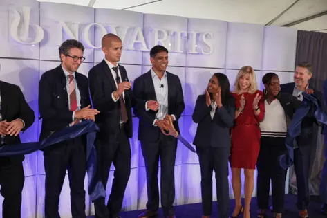 Novartis team at an event on stage smiling together