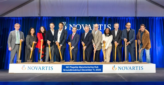 Team shot at the groundbreaking, with shovels in sand. 