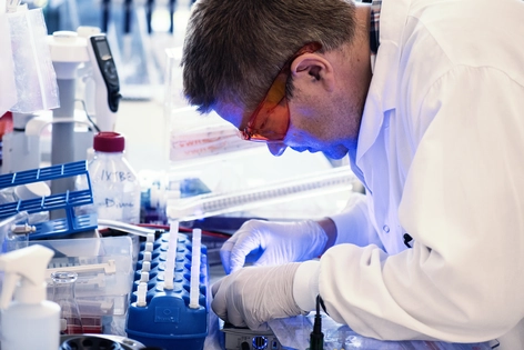 Scientist working in a laboratory with test tubes and scientific equipment