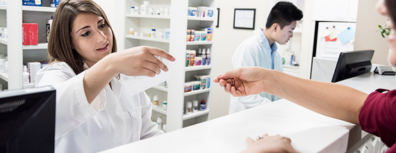 Pharmacist reading customer's prescription