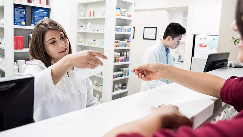 Pharmacist reading customer's prescription