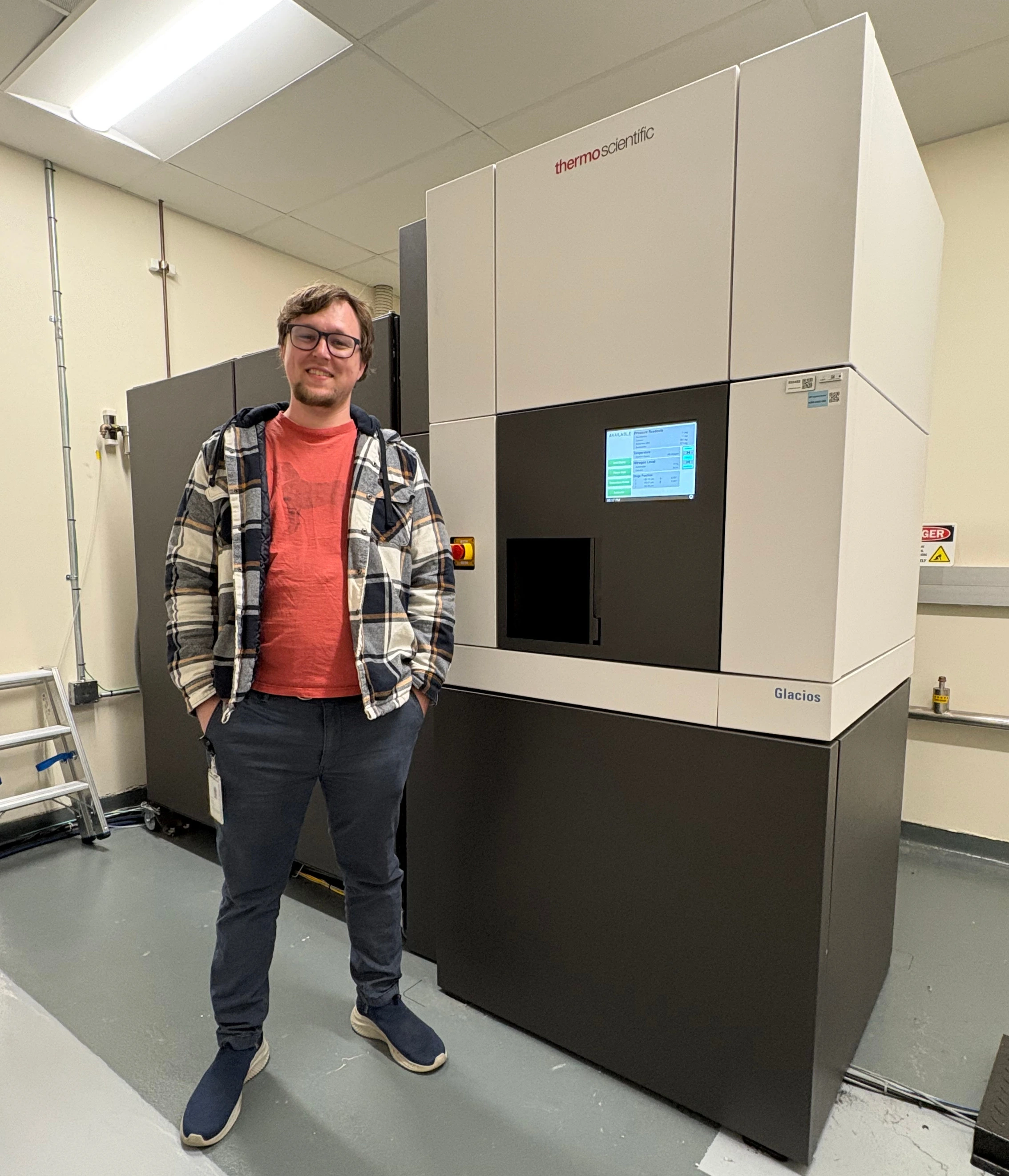 Colin, standing in front of a cryo-electron microscope at Novartis.