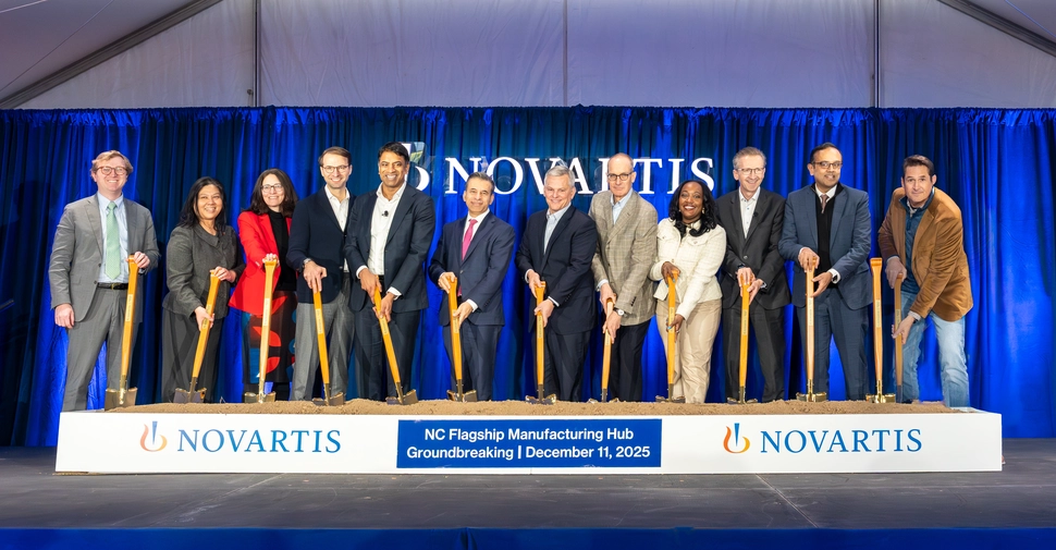 Team shot at the groundbreaking, with shovels in sand. 