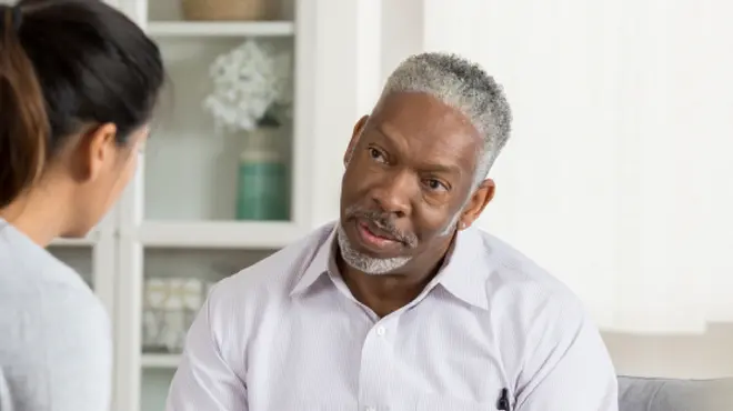 Prostate cancer patient in discussion with social worker about navigating treatment and support services